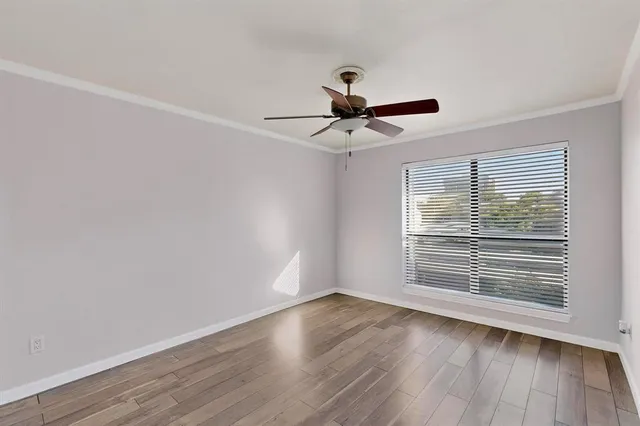 a view of wooden floor and a chandelier fan in a room