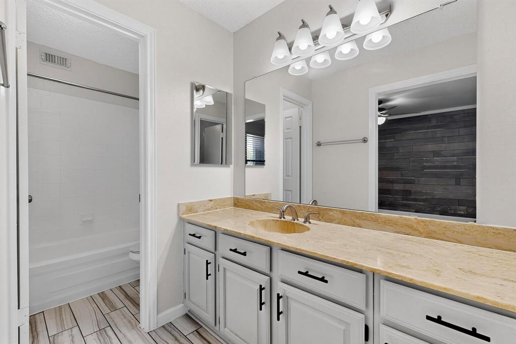 5840 Spring Valley Road, Unit 810 Dallas, TX 75254 - Photo 26 of 40 a bathroom with a granite countertop sink a large mirror and a bathtub