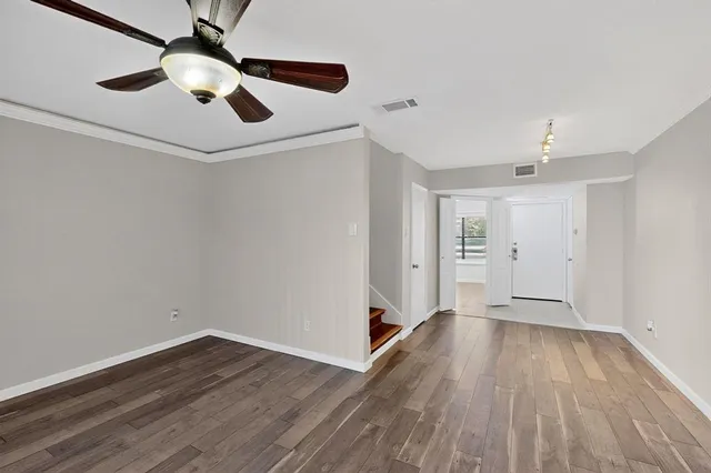 a view of an empty room with wooden floor