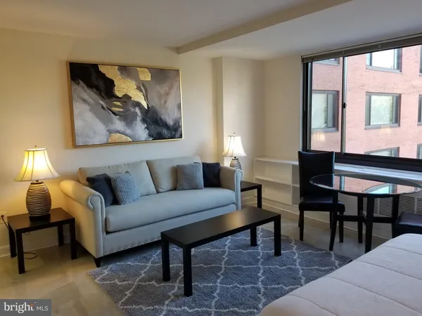 a living room with furniture and a painting on the wall