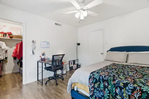 a spacious bedroom with a bed and a flat screen tv