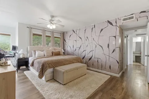a spacious bedroom with a large bed and a chandelier