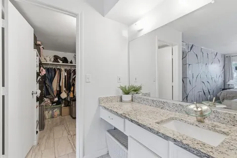 a bathroom with a granite countertop sink and a mirror