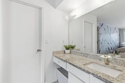 a bathroom with a granite countertop sink a toilet and shower