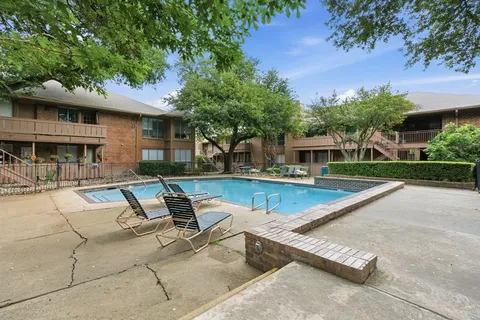a view of a house with large pool plants and large tree