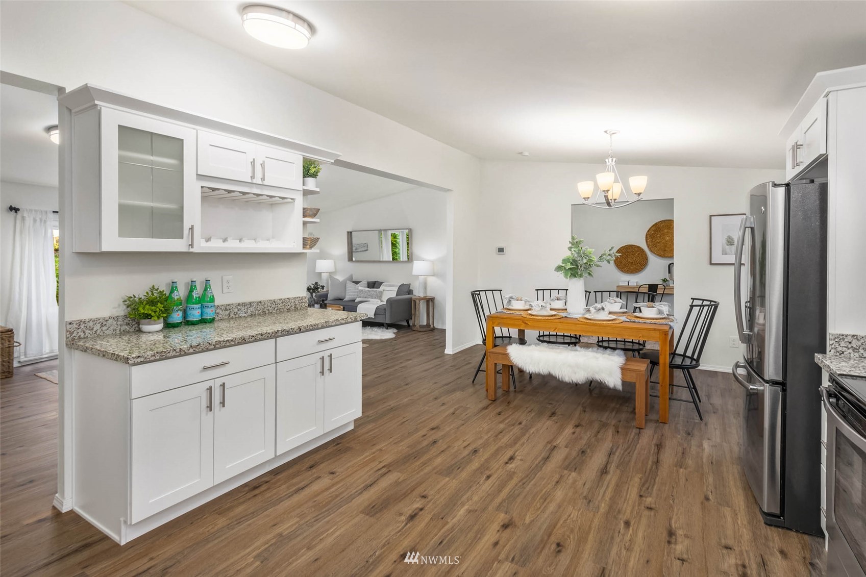 10701 Holly Drive Everett, WA 98204 - Photo 15 of 33 a kitchen with a sink dishwasher a dining table and chairs with wooden floor