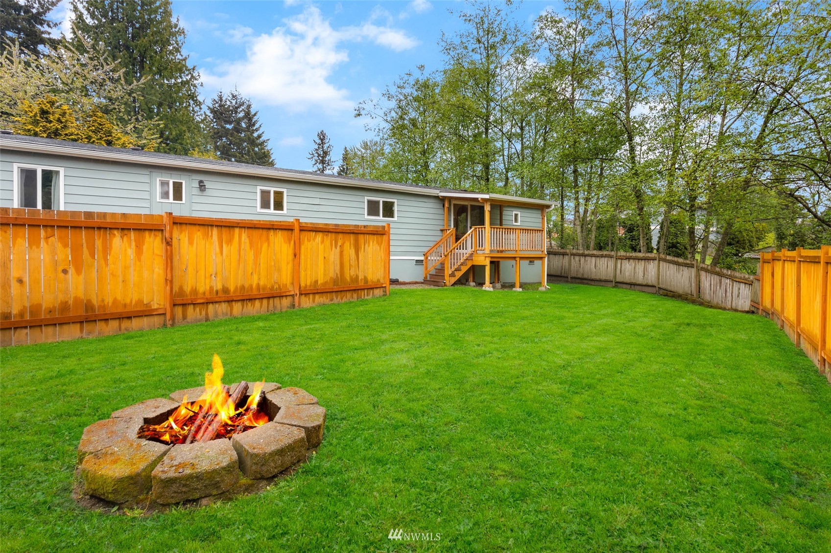 10701 Holly Drive Everett, WA 98204 - Photo 32 of 33 a backyard of a house with table and chairs plants and large tree