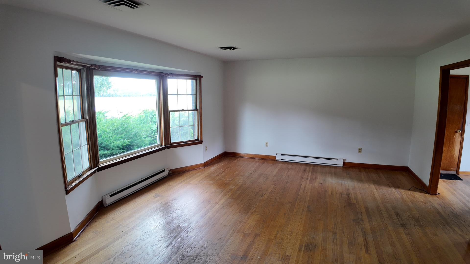 8936 Goldsborough Neck Road Easton, MD 21601 - Photo 8 of 13 a view of an empty room with wooden floor and a window
