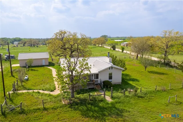 a aerial view of a house with a yard basket ball court and outdoor seating