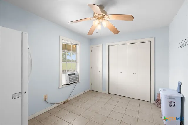 a view of an empty room with window and cabinet