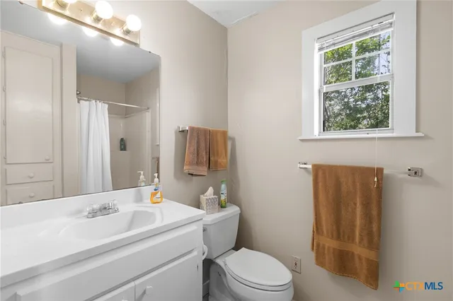a bathroom with a sink toilet and mirror
