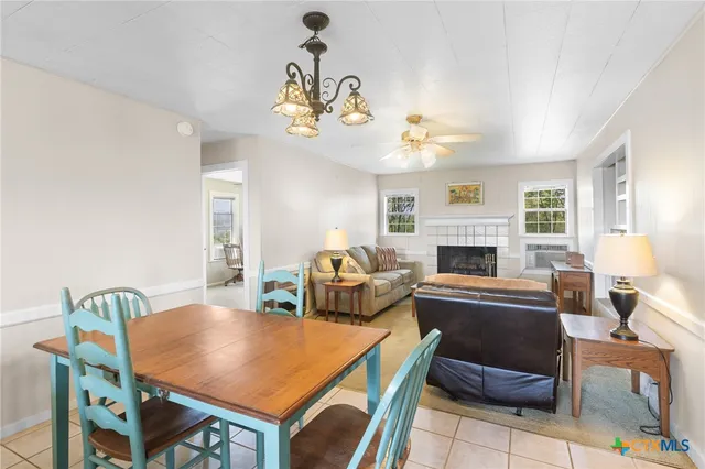 a living room with furniture a dining table and a fireplace
