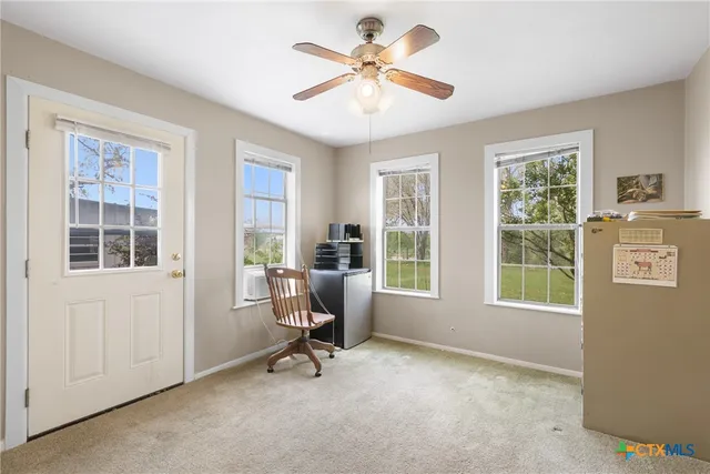 a view of a workspace with furniture and a window