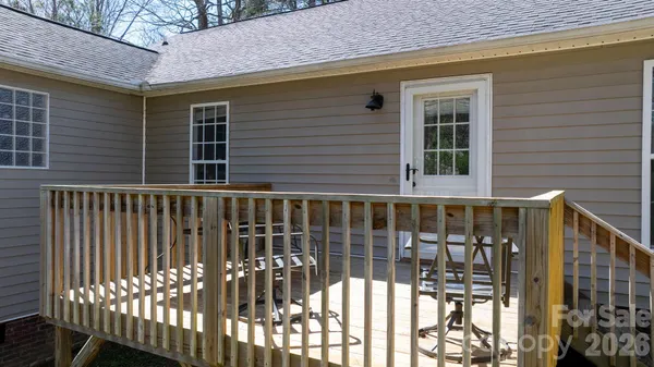 a view of a brick house with a wooden deck