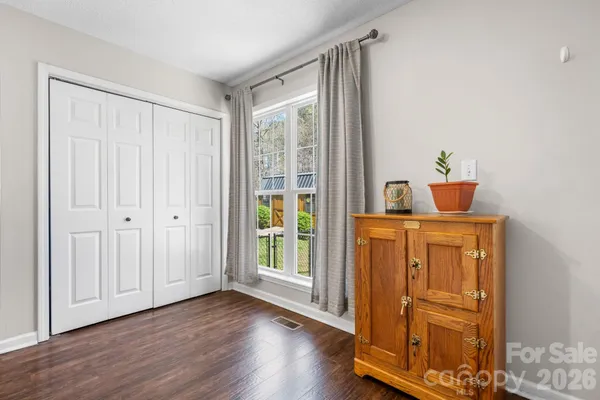 a kitchen with stainless steel appliances granite countertop a refrigerator a stove and white cabinets with wooden floor