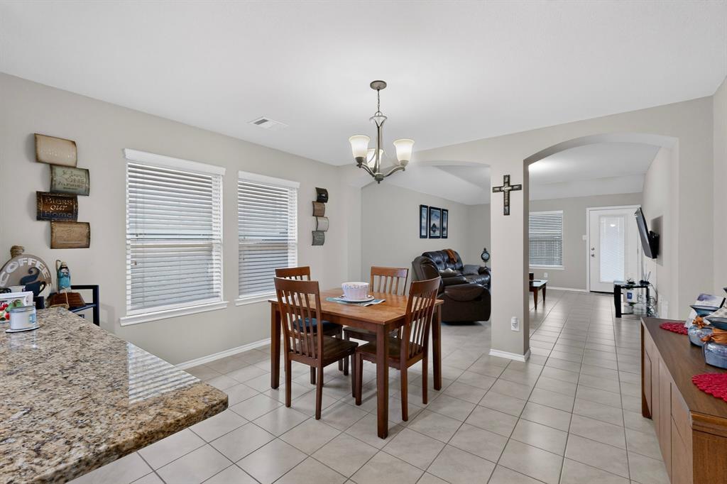1409 Slate Street Princeton, TX 75407 - Photo 7 of 36 Open-concept dining area featuring tiled flooring and a chandelier