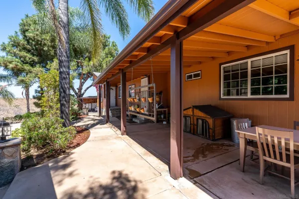a view of a house with backyard and sitting area