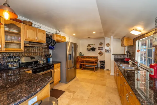 a kitchen with stainless steel appliances granite countertop a stove a sink and a microwave