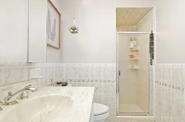 a bathroom with a sink toilet and shower
