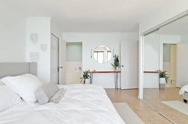 a bedroom with a large bed and a chandelier
