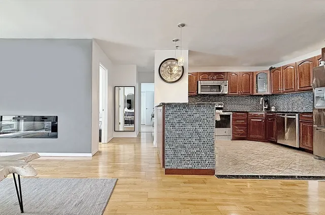 a large kitchen with stainless steel appliances granite countertop a stove a sink and a microwave