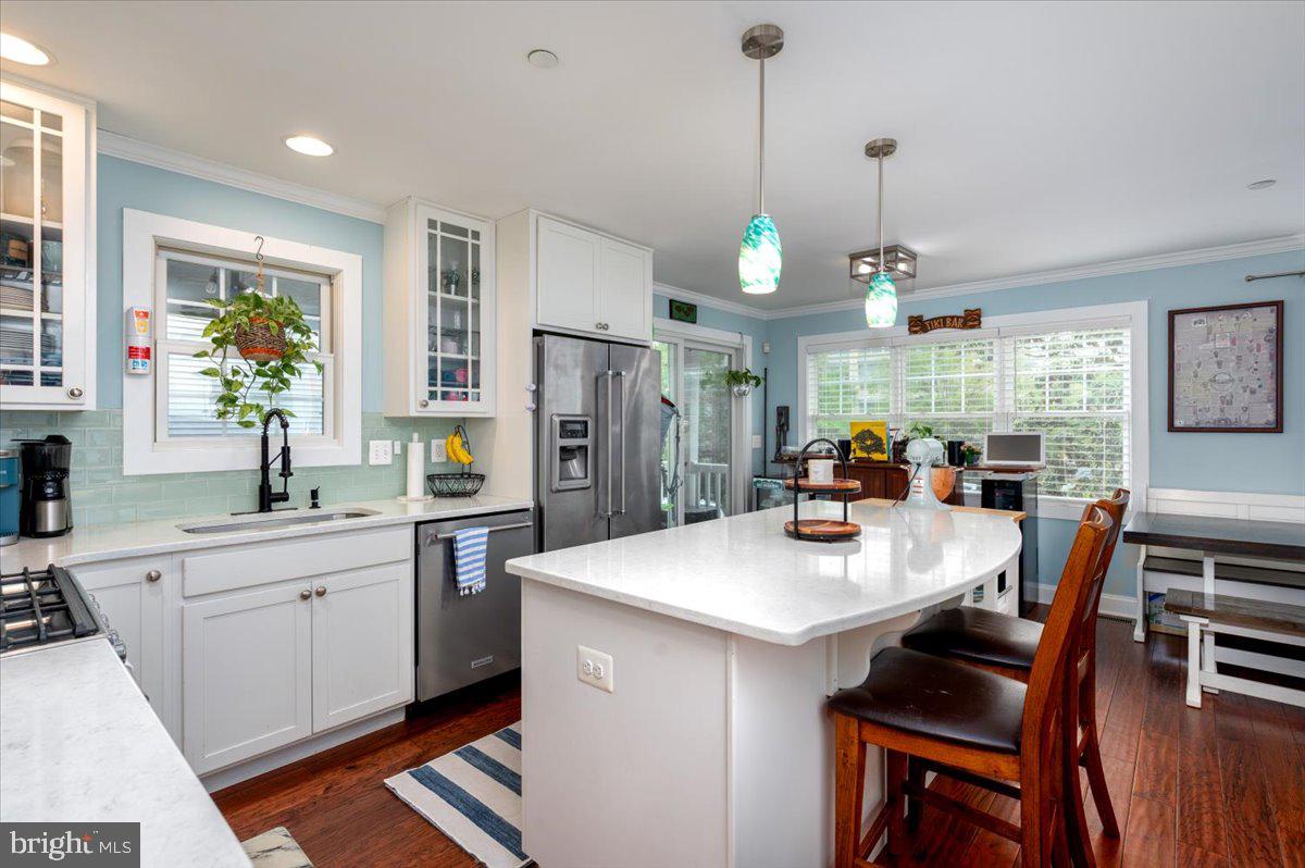 57 Spa Road Annapolis, MD 21401 - Photo 13 of 39 a open kitchen with stainless steel appliances granite countertop a stove a refrigerator a kitchen island a sink dishwasher a dining table and chairs with wooden floor