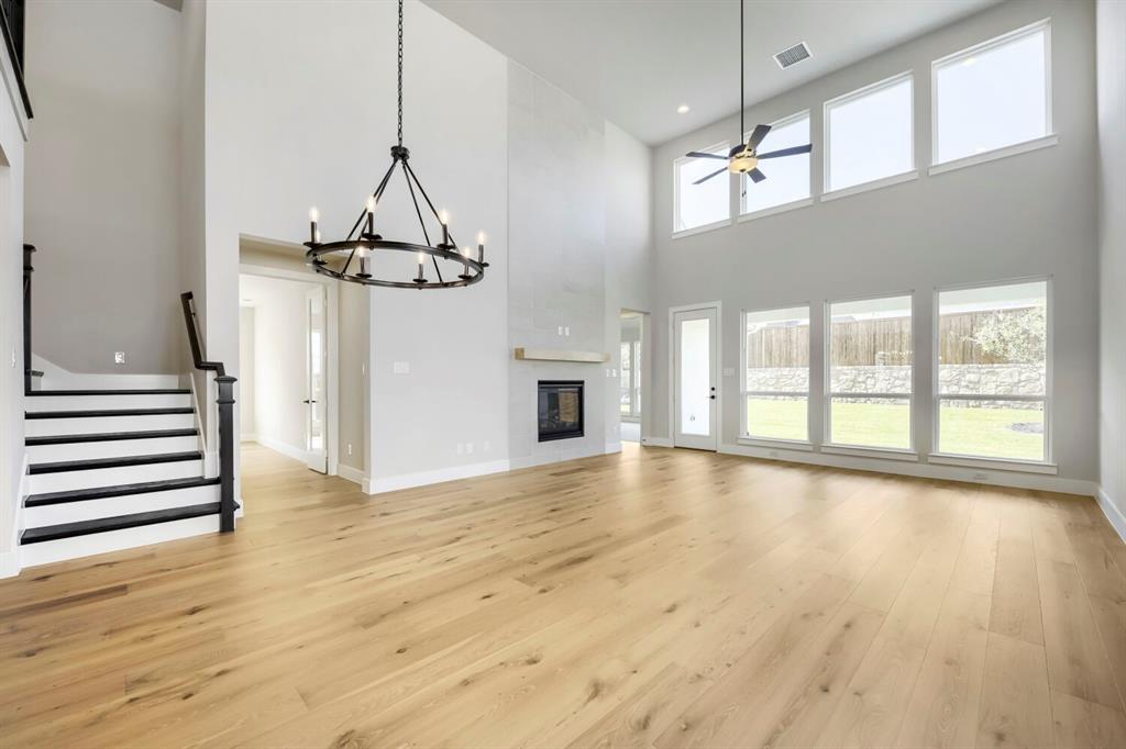 800 Blackberry Road Haslet, TX 76052 - Photo 3 of 28 Expansive living space featuring high ceilings, wood-finish flooring, and a contemporary fireplace