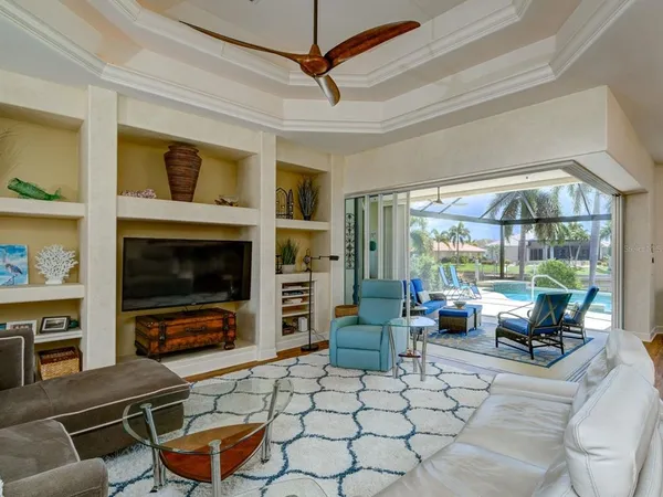 a living room with furniture a flat screen tv and a floor to ceiling window