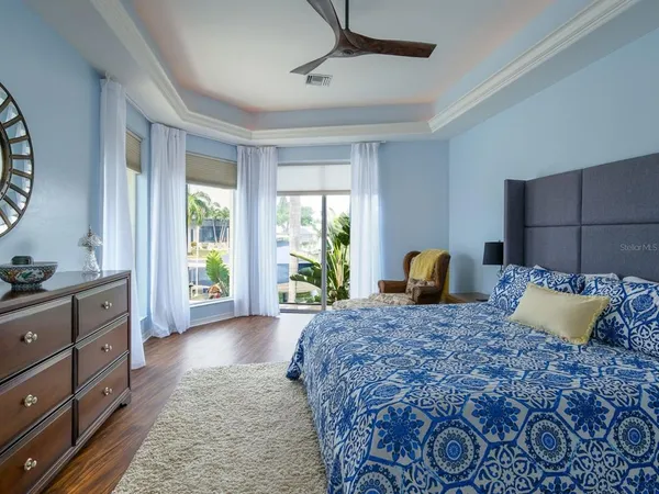 a spacious bedroom with a bed a dresser and next to a window