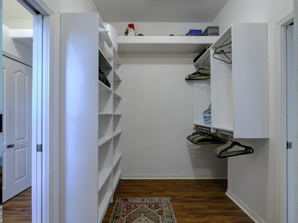 a view of walk in closet with clothes and shoes