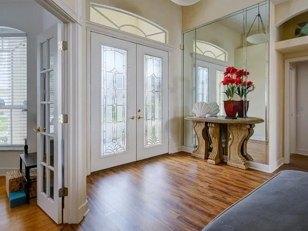 a view of a hallway with wooden floor and dining room view