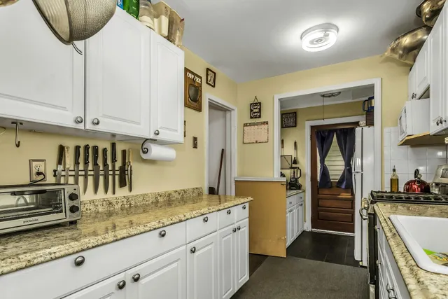 a kitchen with granite countertop a sink and cabinets