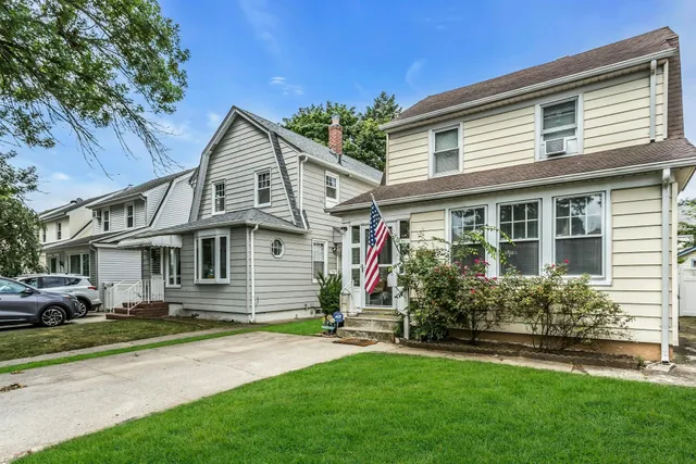 a front view of a house with a garden and plants