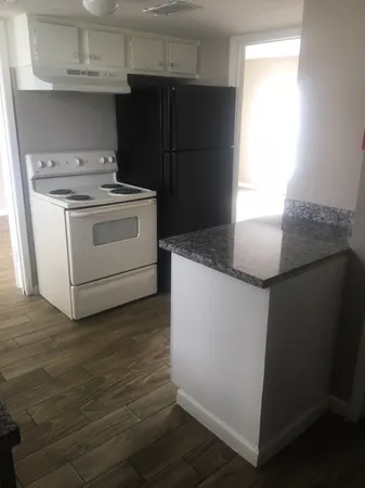 a kitchen with granite countertop cabinets appliances and a window