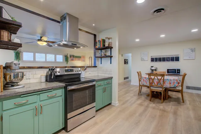 a kitchen with stainless steel appliances granite countertop wooden floors and stove