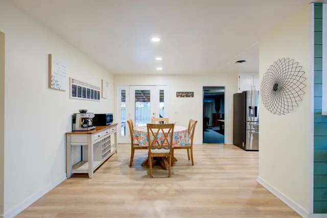 a living room with furniture a refrigerator and a dining table