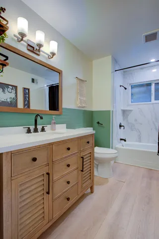 a bathroom with a double vanity sink toilet mirror and bathtub