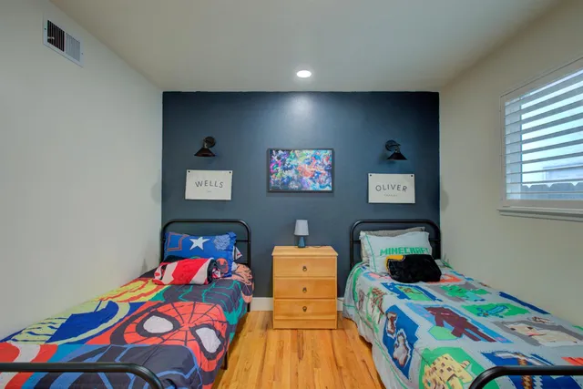a kids bedroom with a bed and a wooden floor
