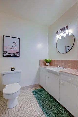 a bathroom with a toilet a sink and mirror