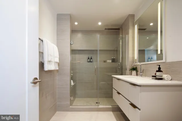 a bathroom with a shower sink and mirror