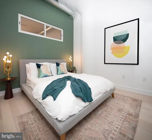 a bedroom with a bed and painting on the wall
