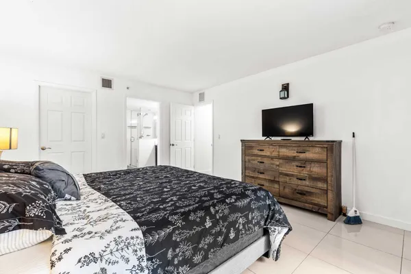 a bedroom with a bed and a flat screen tv