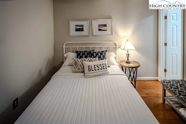 a bed sitting in a bedroom and next to a lamp