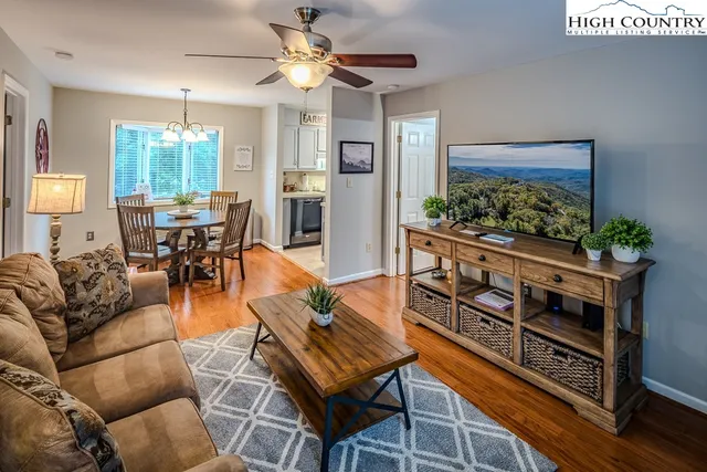 a living room with furniture a window and a flat screen tv