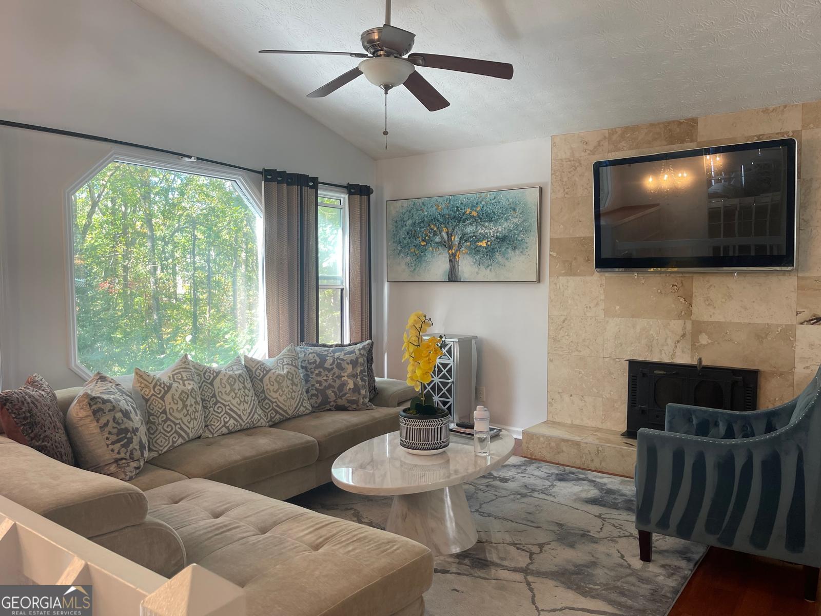 5421 Burdette Road Southeast Mableton, GA 30126 - Photo 24 of 64 a living room with furniture a flat screen tv and a fireplace