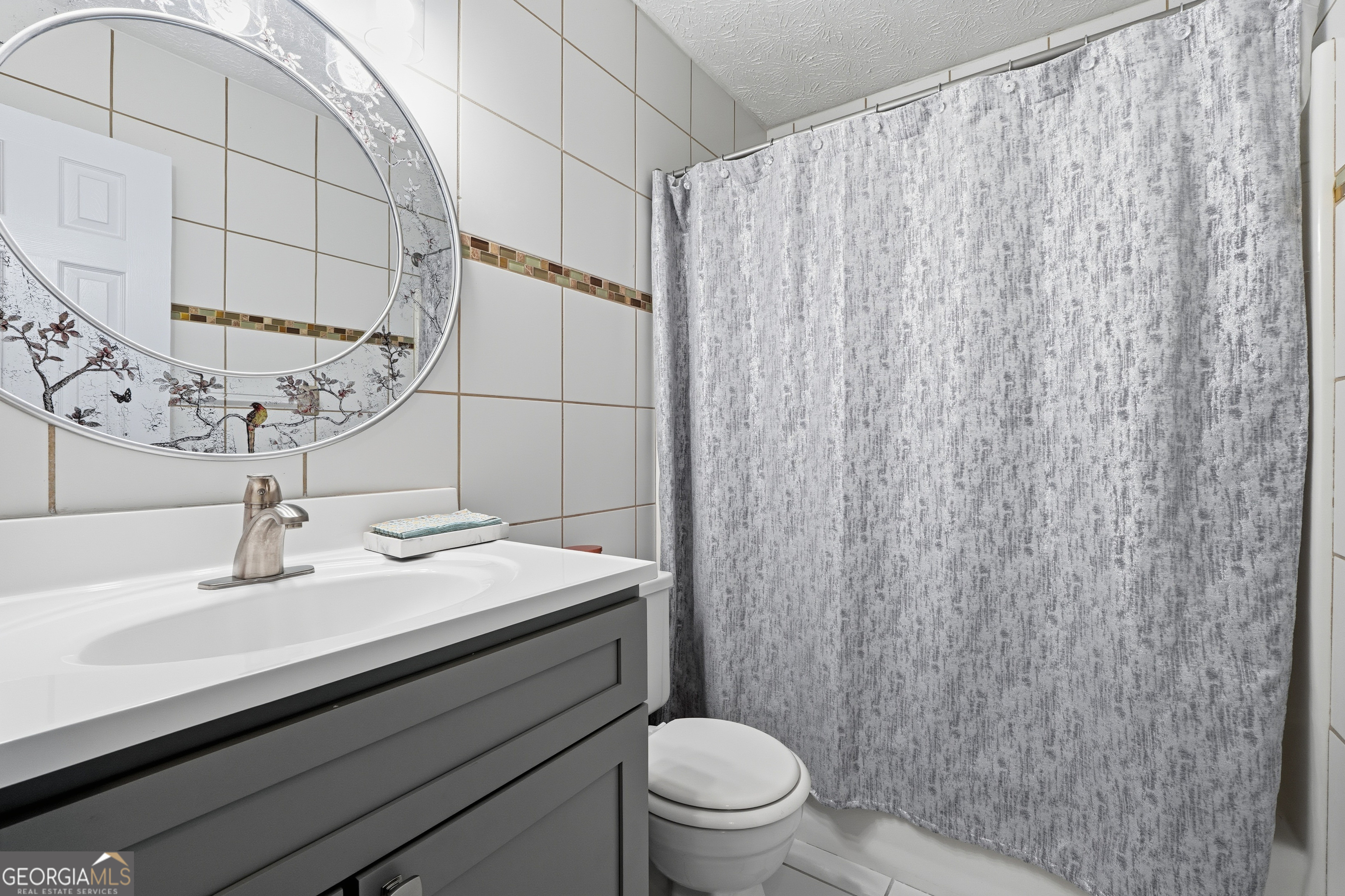 5421 Burdette Road Southeast Mableton, GA 30126 - Photo 43 of 64 a bathroom with a sink a toilet and shower curtain