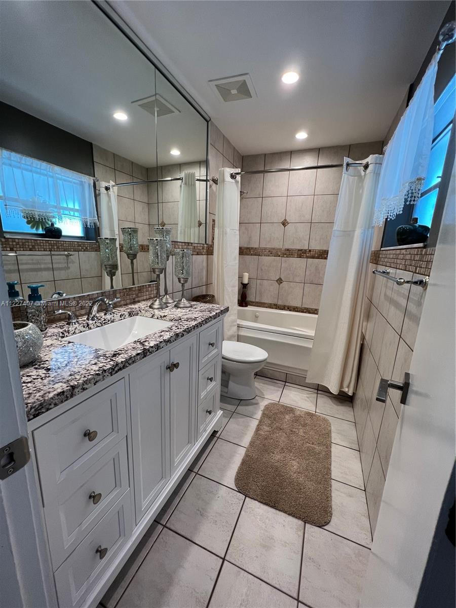 9264 Southwest 18th Road Boca Raton, FL 33428 - Photo 54 of 63 a bathroom with a double vanity sink a toilet and shower