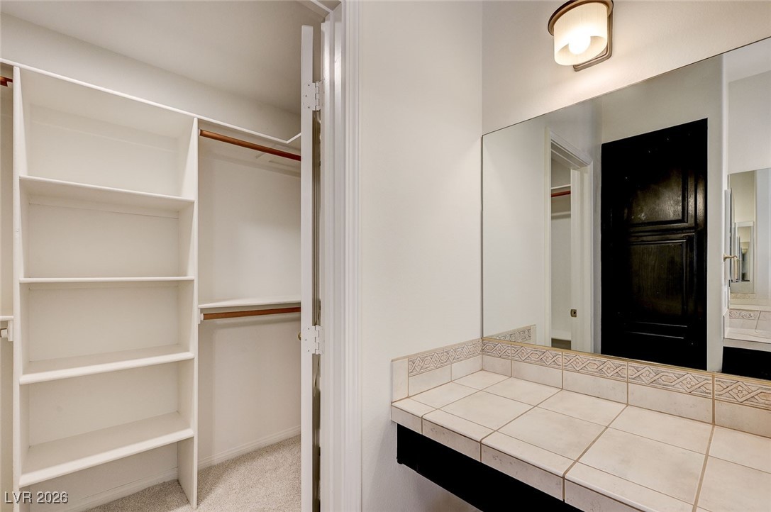 2955 El Camino Road Las Vegas, NV 89146 - Photo 58 of 99 Bathroom featuring a walk in closet, vanity, and light carpet