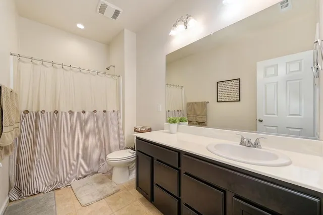a bathroom with a double vanity sink toilet and a mirror