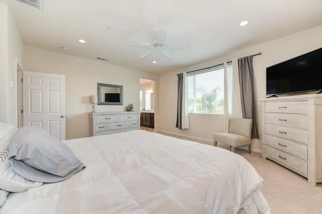 a bedroom with a large bed and a flat screen tv